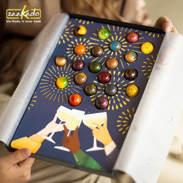 Nieuwjaarsgeschenk met kleurrijke bonbons, gouden vuurwerkillustraties en feestelijke champagneglazen.